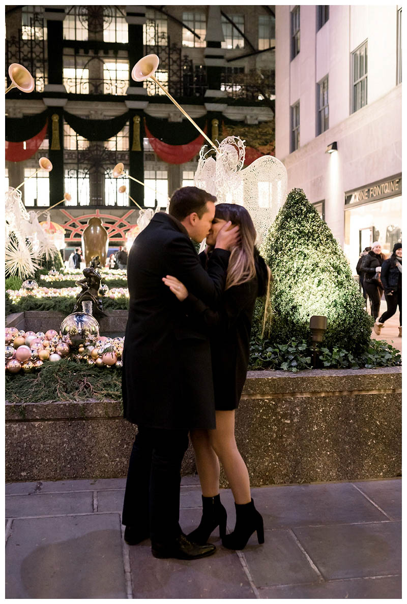 Engaged couple kisses at Rockefeller Center