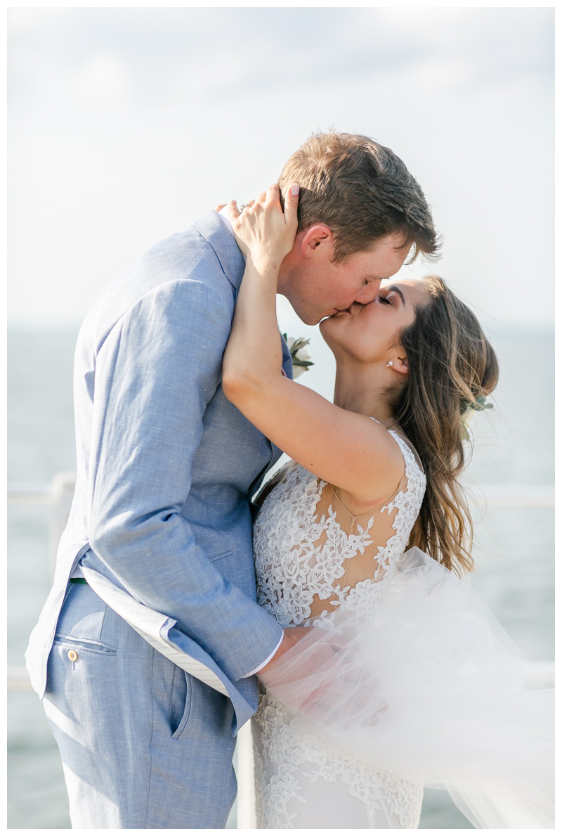 Bride and groom kiss on Long Island beach at Creek Club Long Island wedding