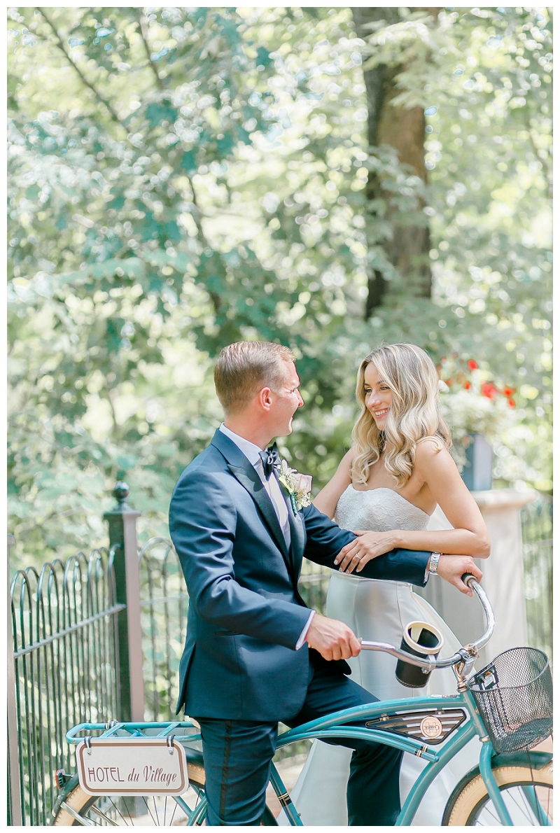 bride and groom with vintage bicycle at hotel du village wedding