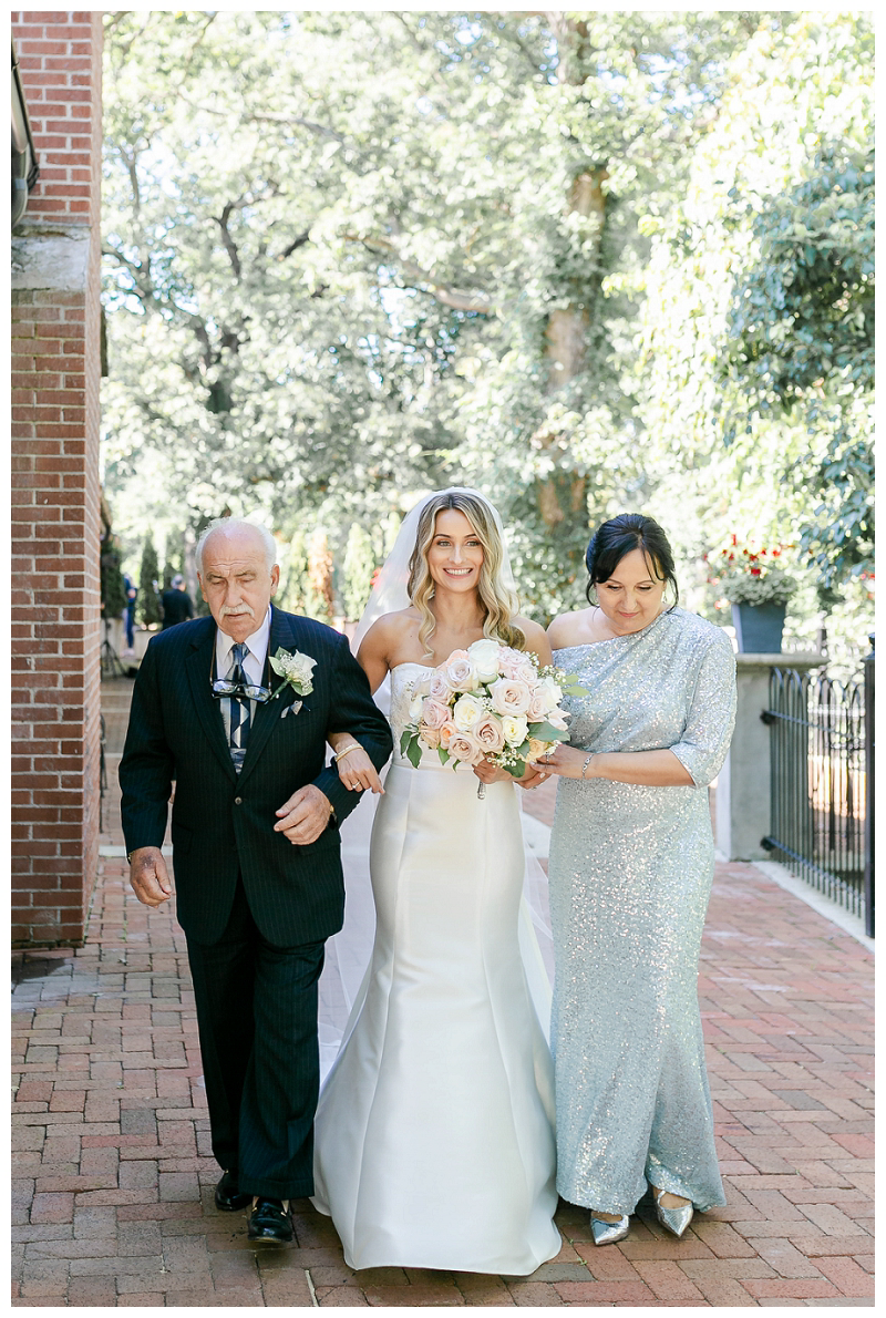 bride walking with mom and dad down aisle