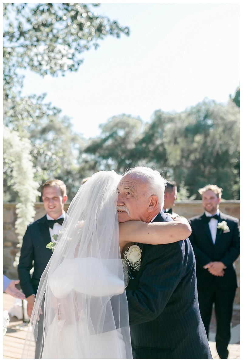 bride hugs dad at estate wedding ceremony